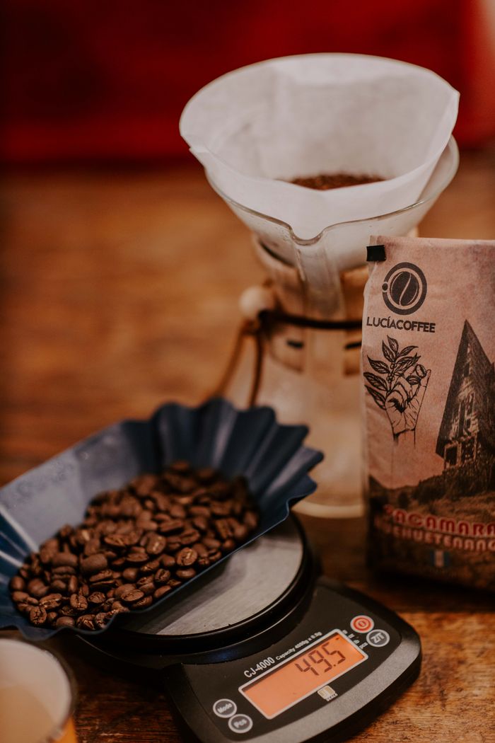 Mastering the First Impression: Your intriguing post title goes here Close-up of coffee beans on a scale with dripper and packaging in Huehuetenango, Guatemala.